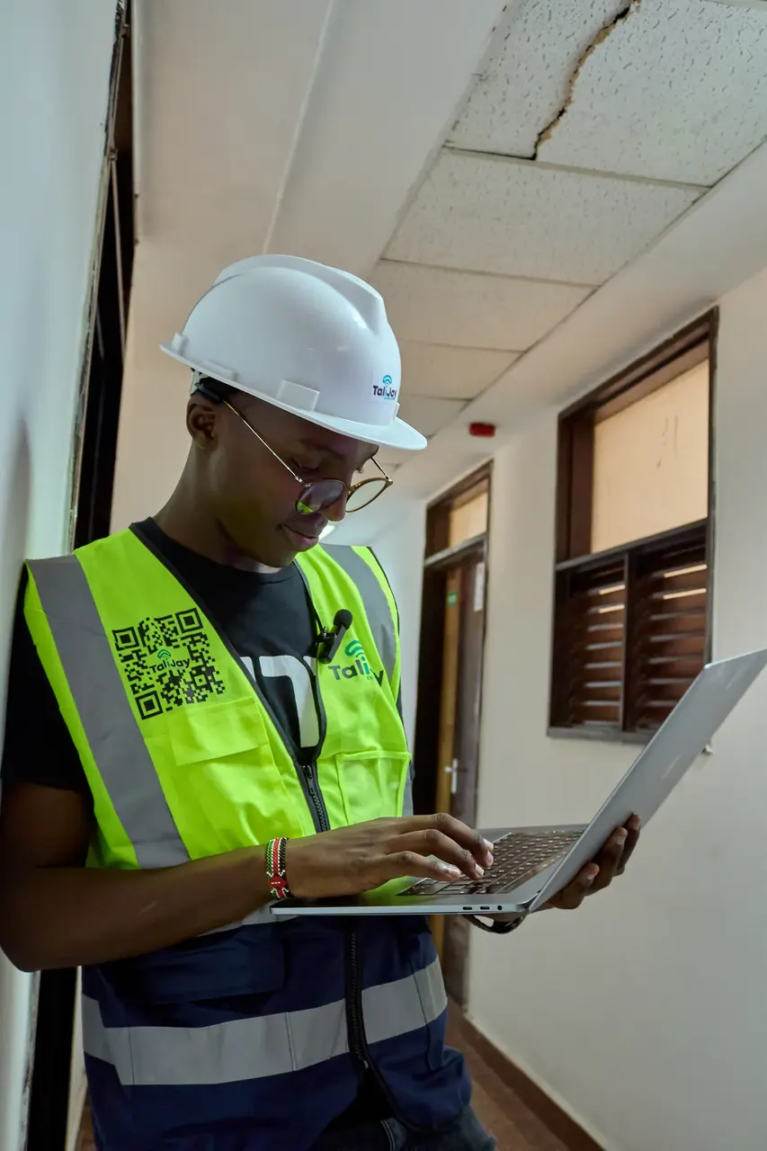 On-site corporate portrait of an engineer reviewing plans on a laptop